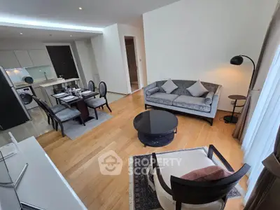 Elegant living room with modern furniture and open kitchen layout in a stylish apartment.