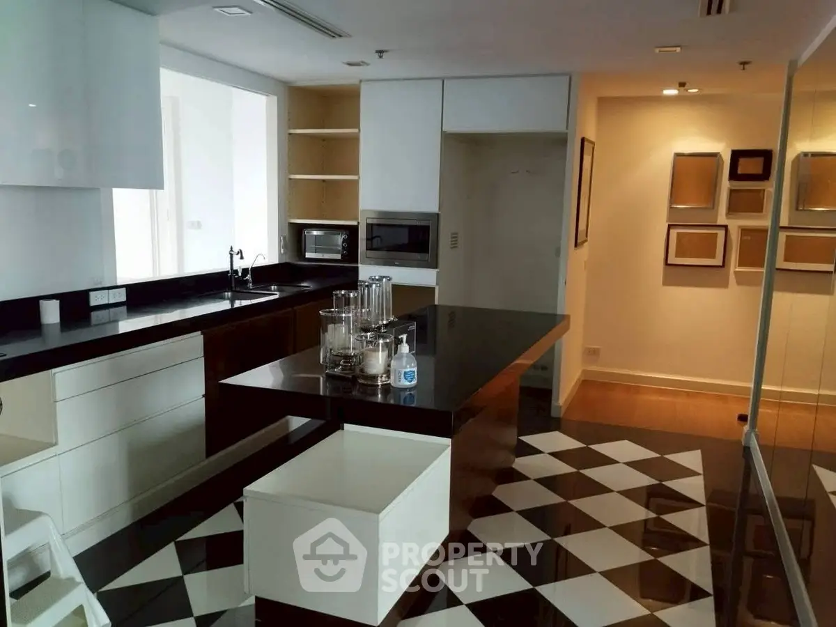 Modern kitchen with sleek black countertops and checkered floor tiles