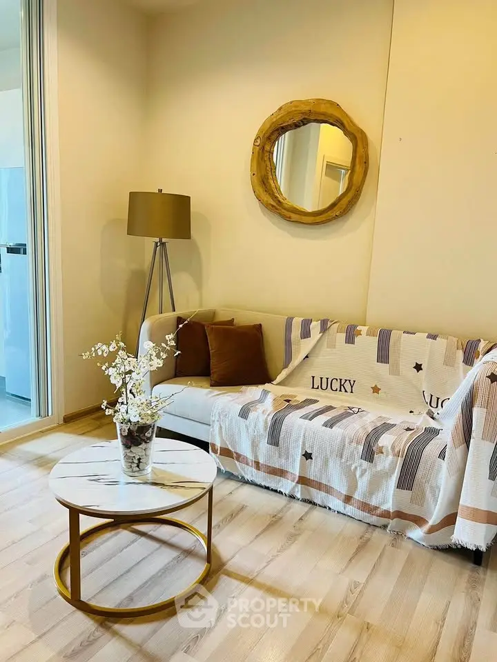 Cozy living room with stylish decor, featuring a modern sofa, elegant floor lamp, and chic round coffee table.