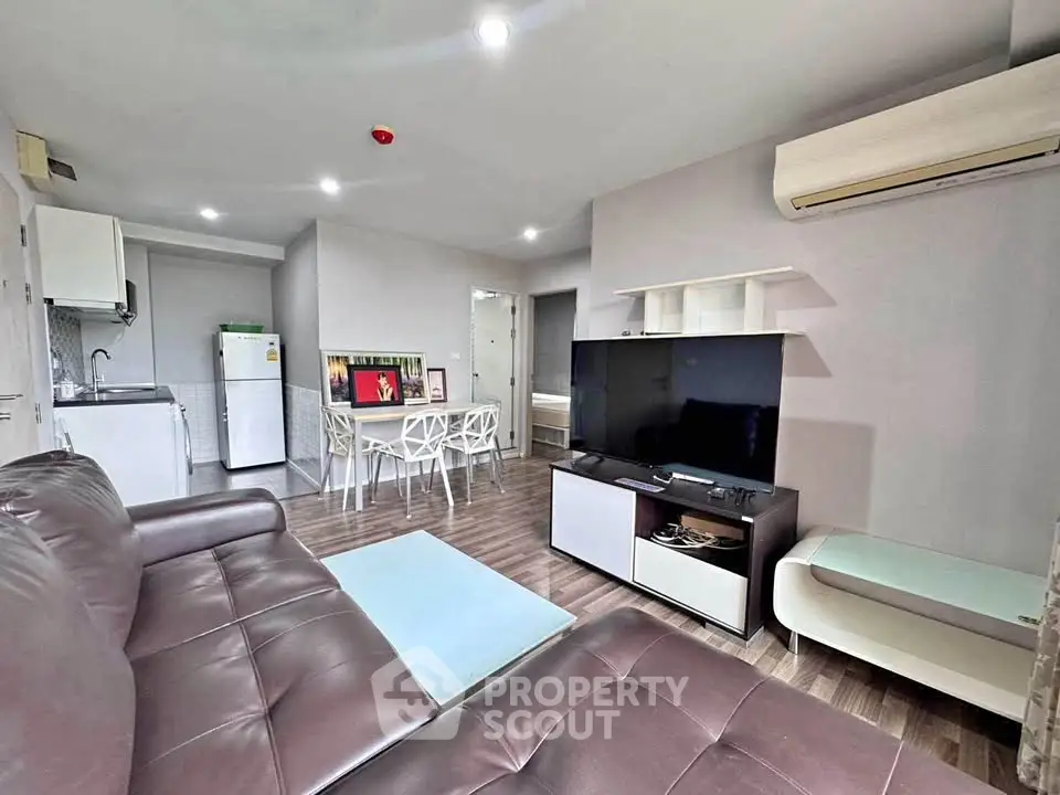 Modern living room with sleek furniture and open kitchen layout in a stylish apartment.