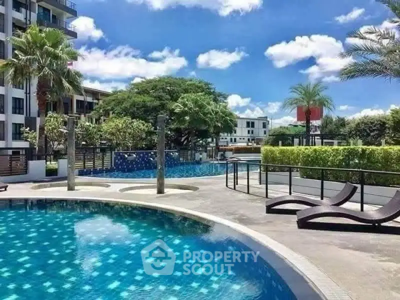 Luxurious poolside view with modern lounge chairs and lush greenery in a high-end residential complex.