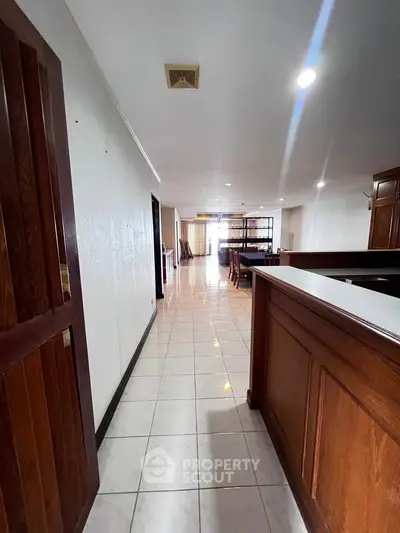 Spacious open-layout interior with tiled flooring and wooden accents, ideal for modern living.