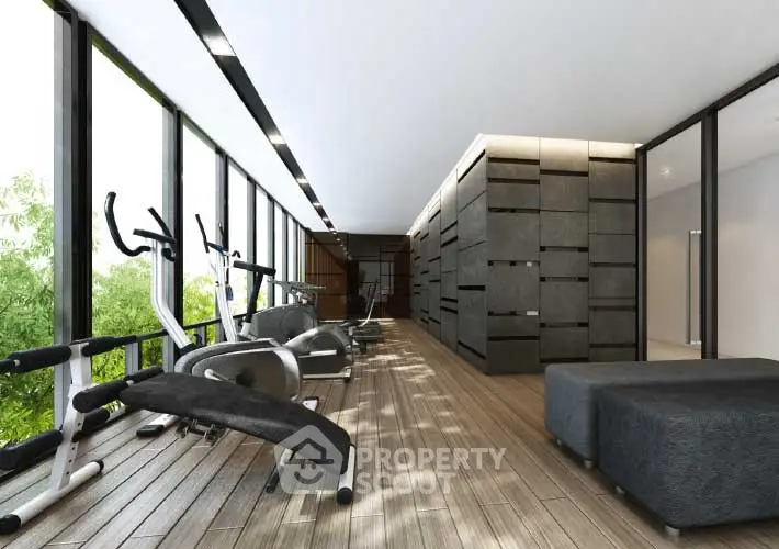 Modern gym with sleek equipment and floor-to-ceiling windows offering a lush green view.
