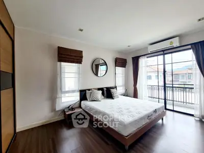 Spacious bedroom with modern decor and balcony access in a stylish home.