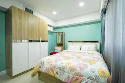 Cozy bedroom with floral bedding and modern wardrobe in a bright apartment