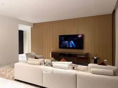 Luxurious modern living room with elegant furniture and large TV, perfect for relaxation and entertainment.