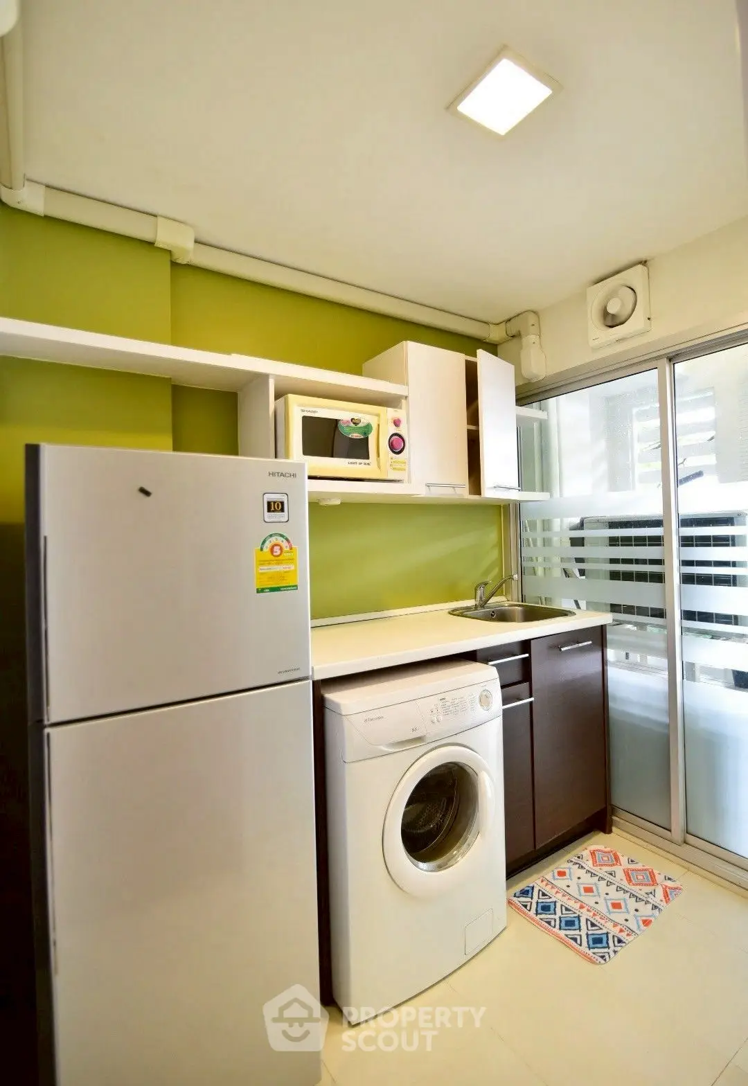 Modern kitchen with washing machine and fridge in compact layout