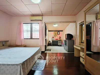 Spacious bedroom with wooden flooring and vintage decor