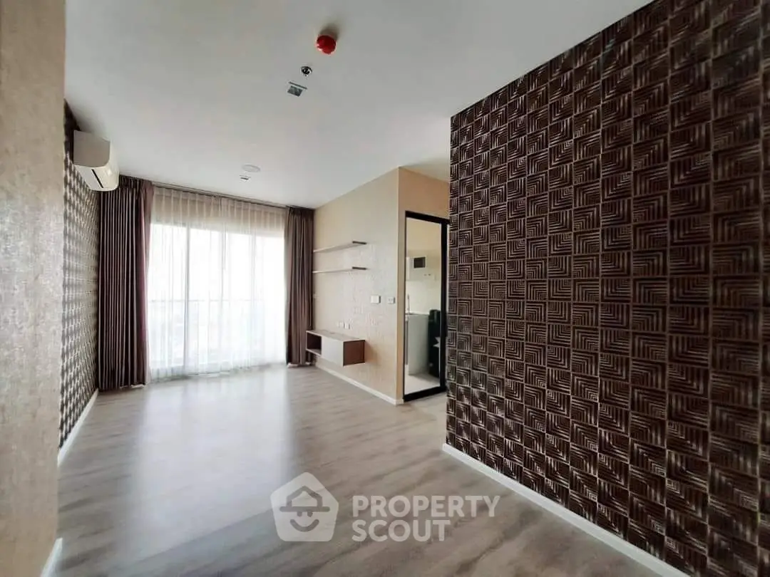 Spacious modern living room with elegant wood flooring and stylish wall design, perfect for urban living.