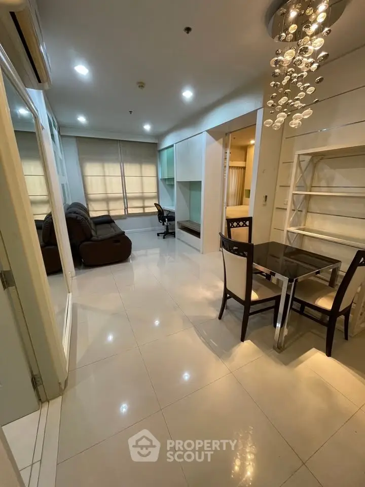 Modern apartment interior with open living and dining area, featuring stylish lighting and contemporary furniture.