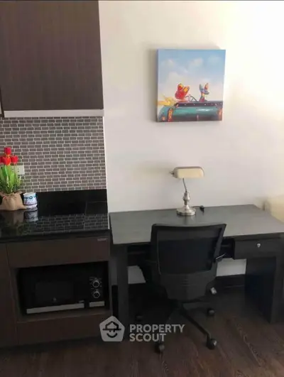 Modern study nook with sleek desk, chair, and wall art in stylish apartment.