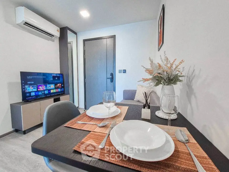 Modern living room with dining area, TV, and air conditioning in a stylish apartment.