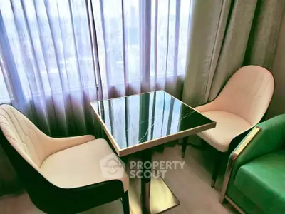 Chic modern living room with elegant chairs and a stylish table by a large window.