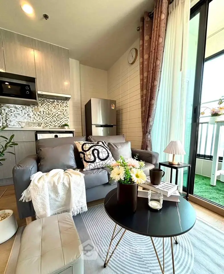 Modern living room with open kitchen and balcony access, featuring stylish decor and natural light.