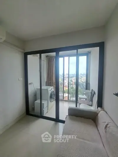 Bright living room with balcony view and washing machine, perfect for modern urban living.