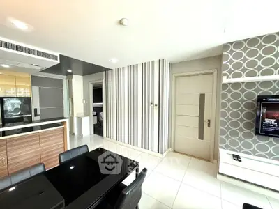 Modern open-plan living room with stylish decor and sleek kitchen area