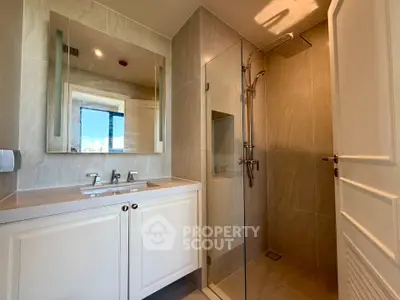 Modern bathroom with glass shower and elegant vanity in a stylish apartment.
