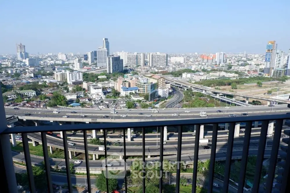 Stunning cityscape view from a high-rise balcony overlooking highways and urban skyline.