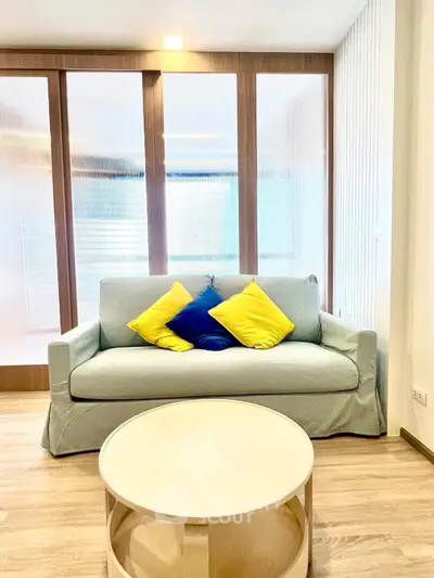 Modern living room with stylish sofa and vibrant cushions, perfect for relaxation.