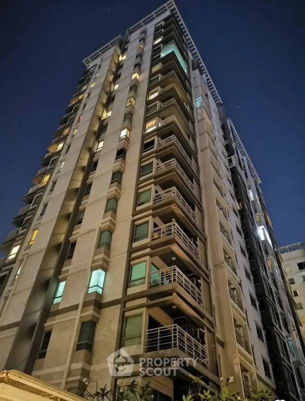 Stunning high-rise building with modern architecture and illuminated windows at night.