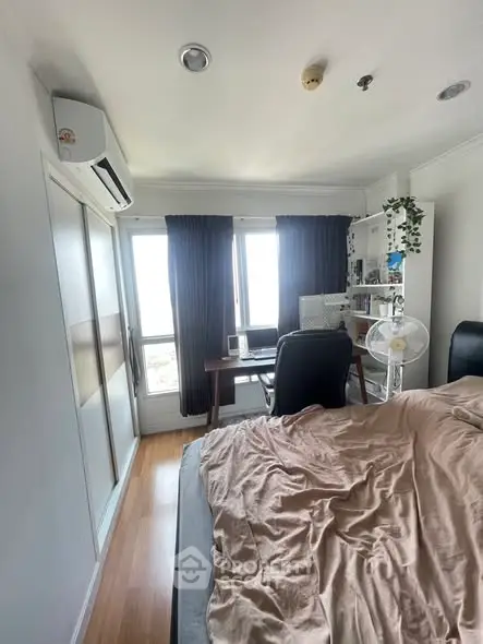 Cozy bedroom with modern decor, featuring a study desk and large windows for natural light.