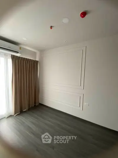 Spacious empty room with elegant wall paneling and large window, perfect for customization.