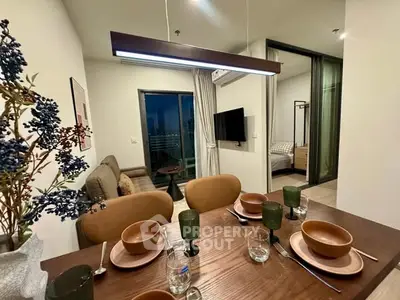 Modern dining area with stylish tableware, open layout to cozy living room and bedroom, perfect for urban living.