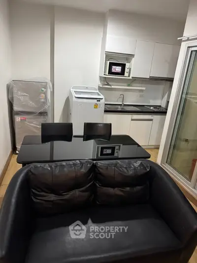 Modern compact kitchen with washing machine and microwave in cozy apartment