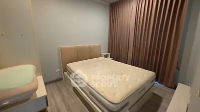 Spacious bedroom with modern design and large window for natural light.