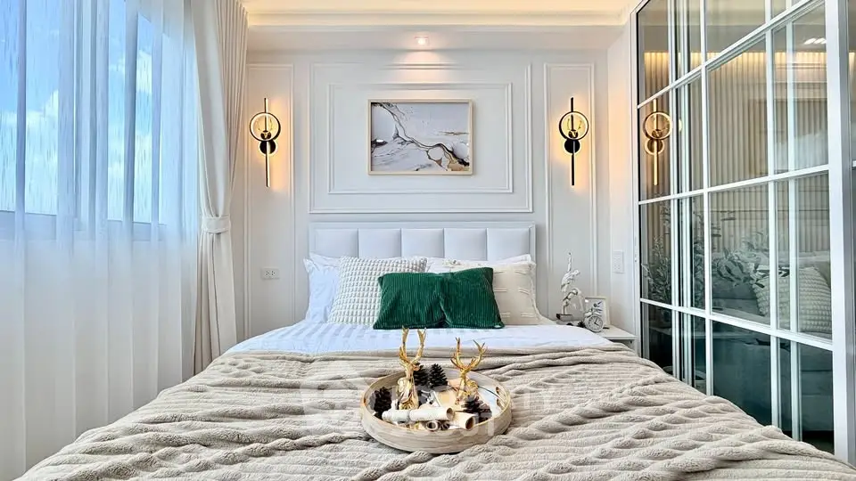 Luxurious bedroom with elegant decor and natural light, featuring plush bedding and stylish wall sconces.
