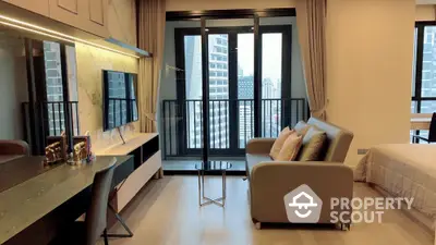 Modern studio apartment with balcony and city view, featuring sleek furniture and contemporary design.