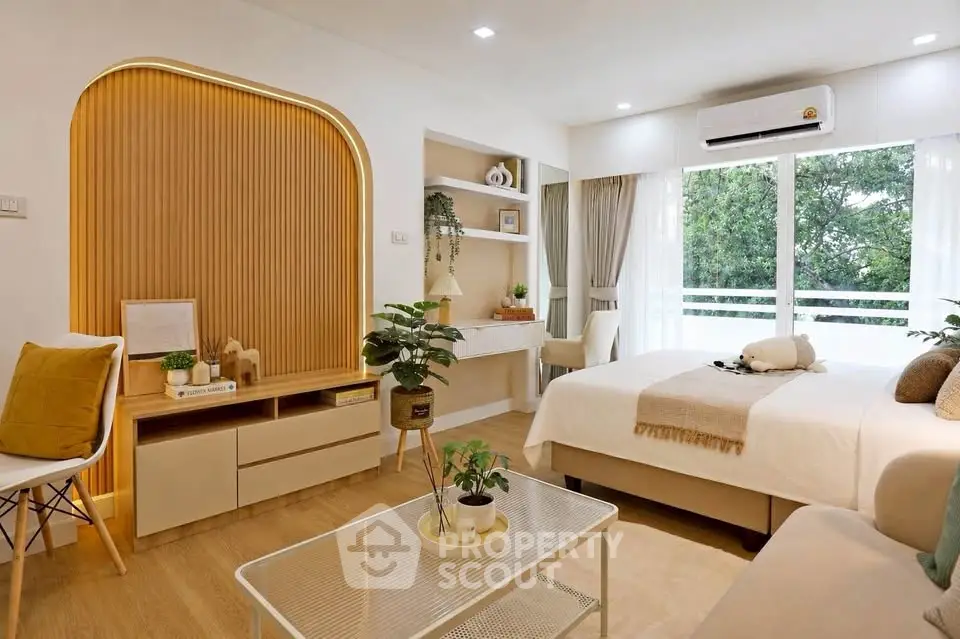Modern bedroom with stylish decor, large window, and cozy seating area, perfect for relaxation and comfort.
