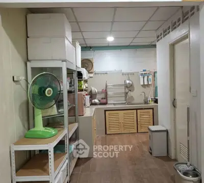 Cozy kitchen with closed layout and ample storage space, featuring a fan and modern appliances.