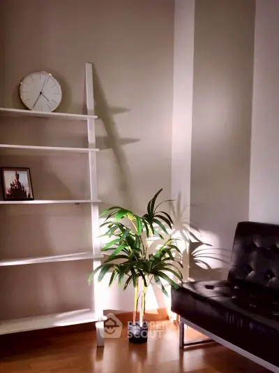 Stylish living room corner with modern shelf, clock, and plant decor.