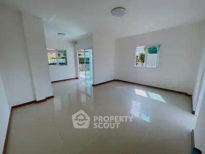Spacious empty living room with large windows and glossy tiled floor