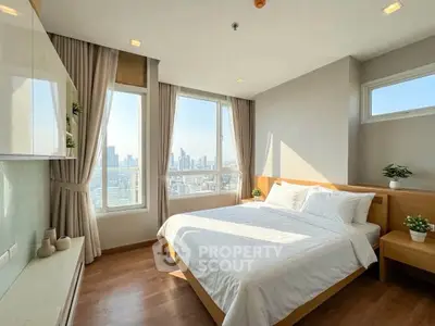 Bright and airy bedroom with city view, modern furnishings, and ample natural light.