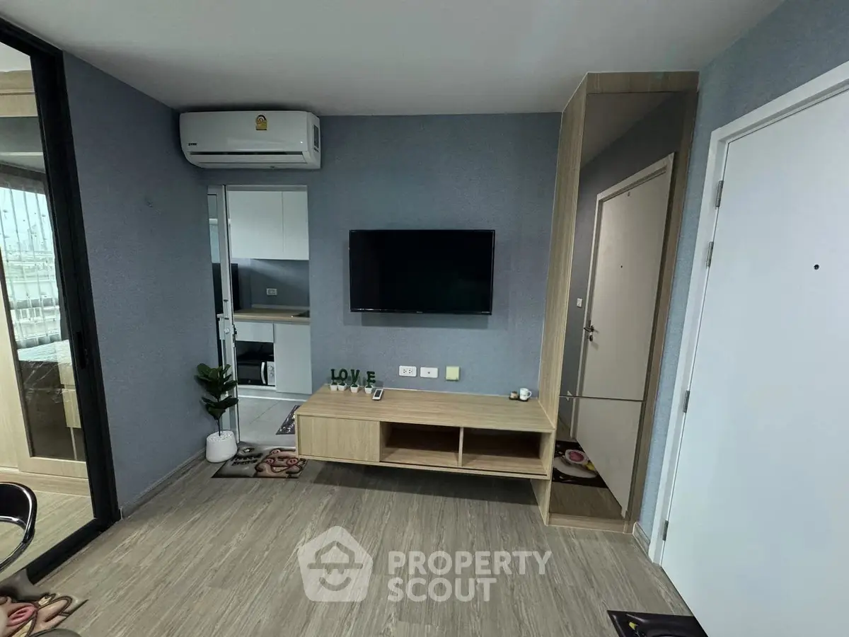 Modern living room with sleek TV setup and stylish decor in a contemporary apartment.