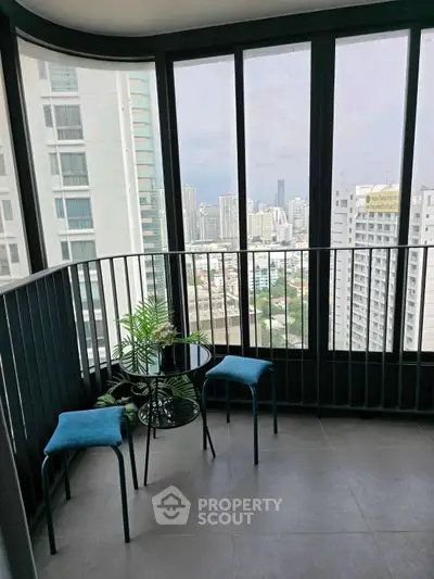Stunning high-rise balcony with panoramic city views and modern seating area.
