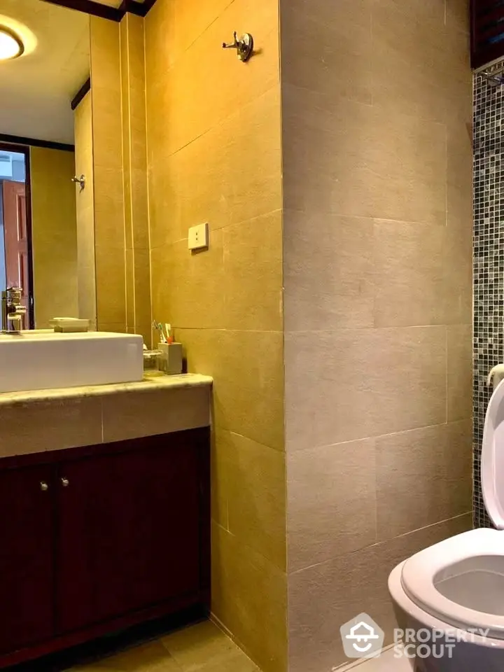 Modern bathroom with stylish sink and tiled walls in a cozy apartment.