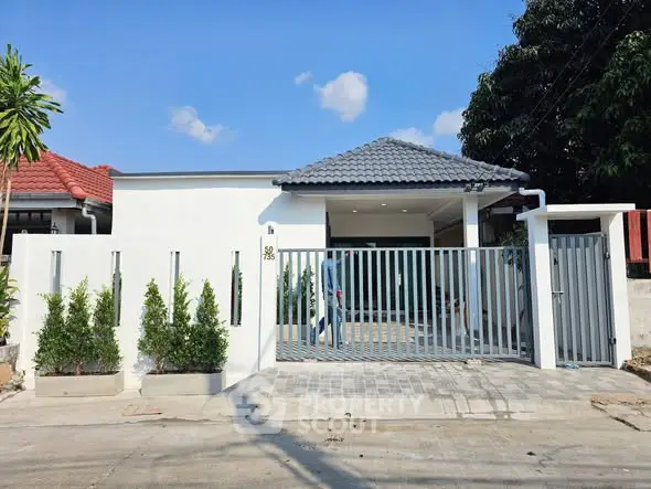 Charming single-story home with modern gate and lush greenery