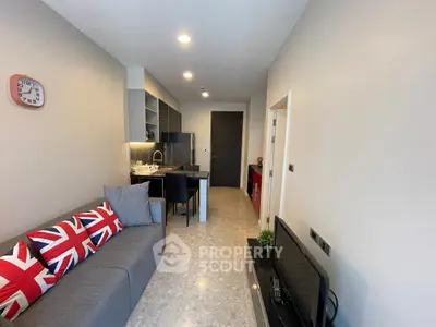 Modern living room with sleek design and open kitchen layout, featuring stylish decor and ample natural light.