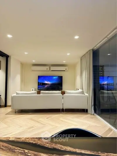 Modern living room with sleek design, featuring a large TV and comfortable seating, perfect for relaxation.