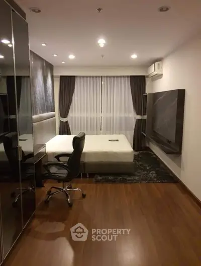 Modern bedroom with sleek design, hardwood floors, and large window for natural light.