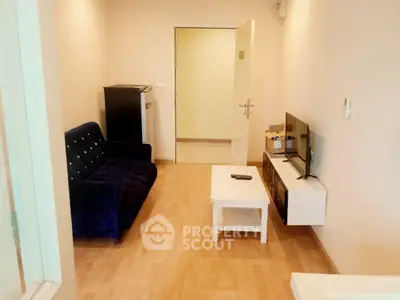 Cozy living room with modern furniture and wooden flooring in a compact apartment.