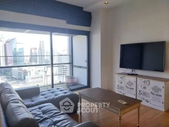 Modern living room with city view, stylish furniture, and large TV setup.