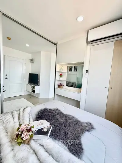 Modern bedroom with cozy decor, featuring a plush bed, built-in wardrobe, and sleek air conditioning unit.