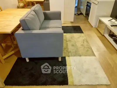 Cozy living room with modern gray sofa and stylish geometric rug