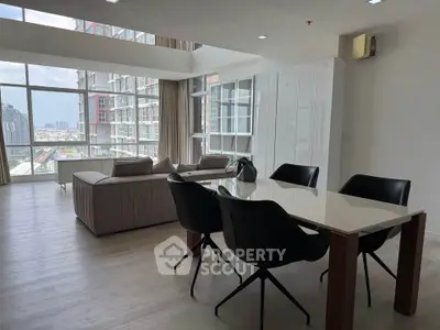 Spacious modern living room with large windows and city view, featuring elegant dining area and stylish furniture.