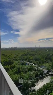 Stunning panoramic view from a high-rise balcony overlooking lush greenery and distant skyline.