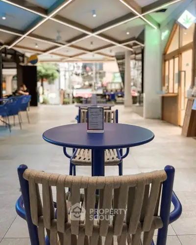Modern open space with stylish seating and unique ceiling design in a commercial area.